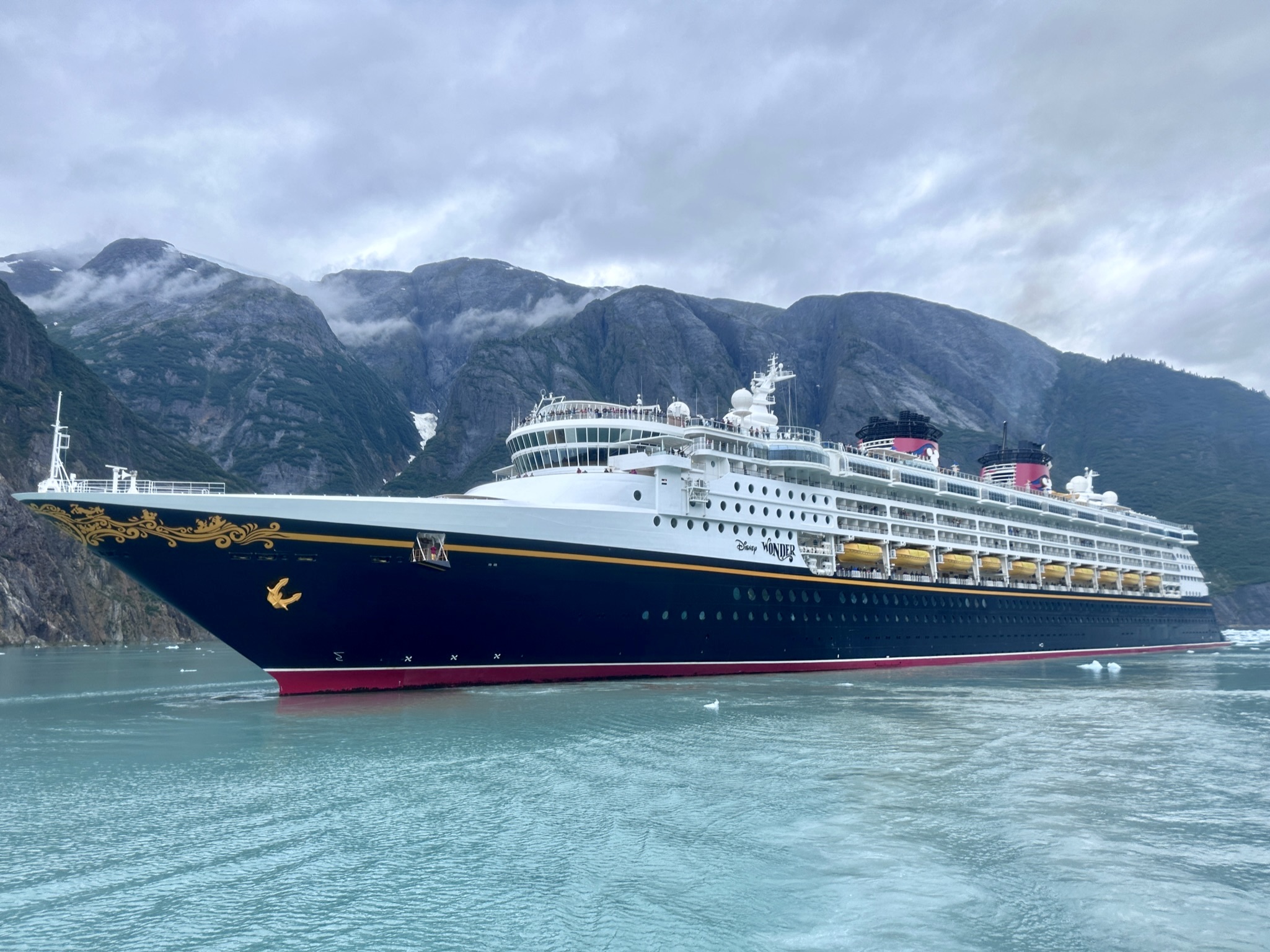 Disney Wonder cruise ship sailing through scenic Alaskan waters
